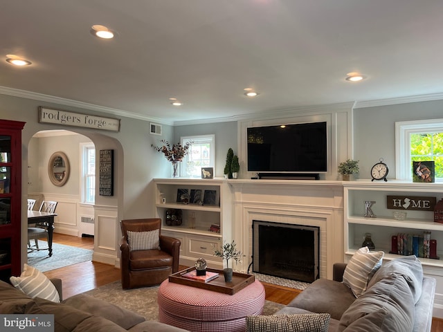 409 Regester Ave, Baltimore, MD 21212 - living room with a fireplace with flush hearth, ornamental molding, radiator heating unit, healthy amount of natural light, and wood finished floors