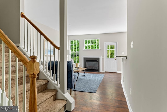 119 Fringetree Dr, West Chester, PA 19380 - living area with dark wood-type flooring, a fireplace with flush hearth, baseboards, and stairs