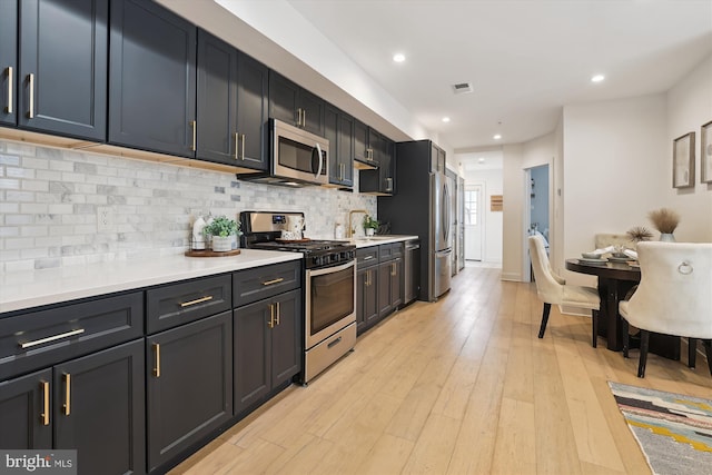 200 Hamilton St NW Unit 2, Washington, DC 20011 - kitchen with stainless steel appliances, decorative backsplash, light countertops, light wood-type flooring, and recessed lighting