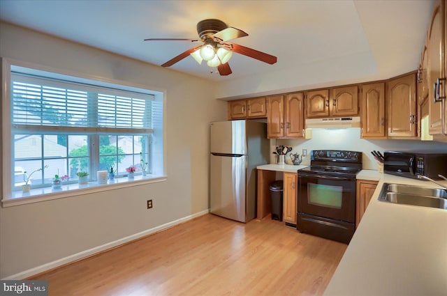 2217 Highland Cir, Harrisburg, PA 17110 - kitchen with black appliances, under cabinet range hood, a sink, a ceiling fan, and light wood-style flooring