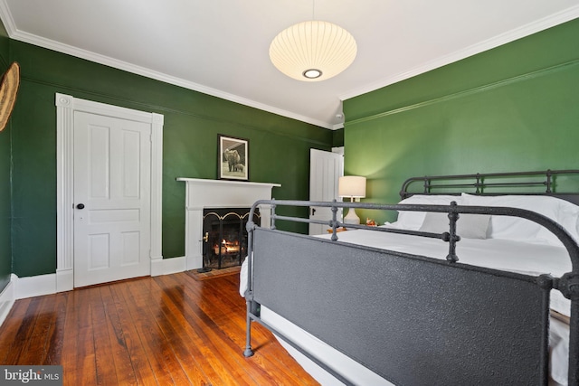 23350 Cedar Mountain Dr, Rapidan, VA 22733 - bedroom featuring crown molding, hardwood / wood-style flooring, a warm lit fireplace, and baseboards
