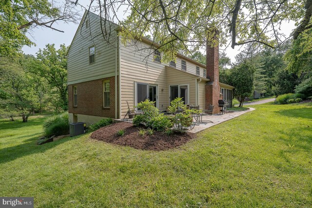 849 Milmar Rd, Newtown Square, PA 19073 - view of side of home with a patio, a yard, a chimney, brick siding, and central AC