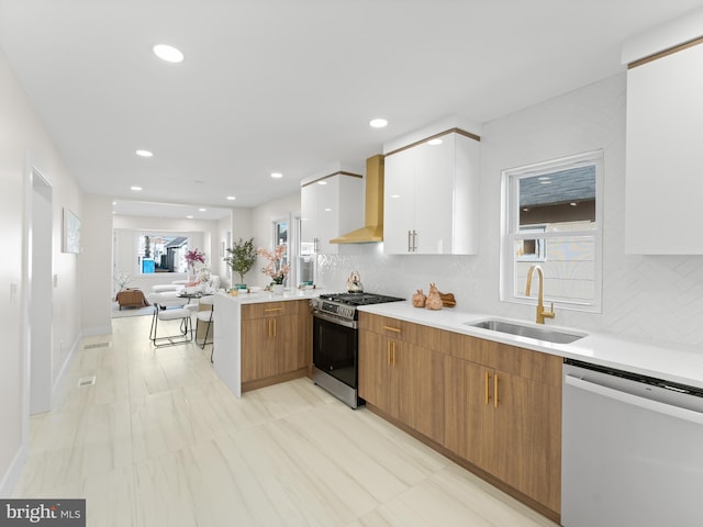 212 W 13th Ave, Wildwood, NJ 08260 - kitchen with stainless steel appliances, a sink, wall chimney exhaust hood, a peninsula, and light countertops