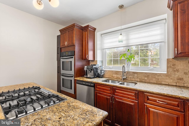 225 Wayne Ave, Lansdowne, PA 19050 - kitchen featuring appliances with stainless steel finishes, a sink, backsplash, and hanging light fixtures