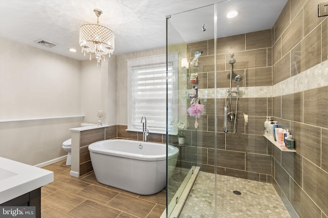 225 Wayne Ave, Lansdowne, PA 19050 - full bath featuring vanity, a freestanding tub, a stall shower, toilet, and a chandelier