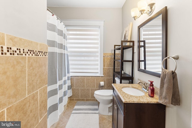225 Wayne Ave, Lansdowne, PA 19050 - bathroom with tile walls, tile patterned floors, toilet, vanity, and healthy amount of natural light