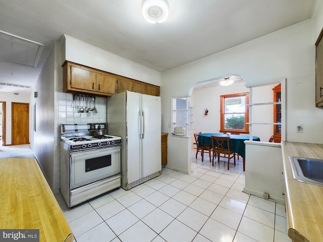 834 Amboy Ave, Edison, NJ 08837 - kitchen featuring white appliances, light countertops, arched walkways, tasteful backsplash, and brown cabinetry