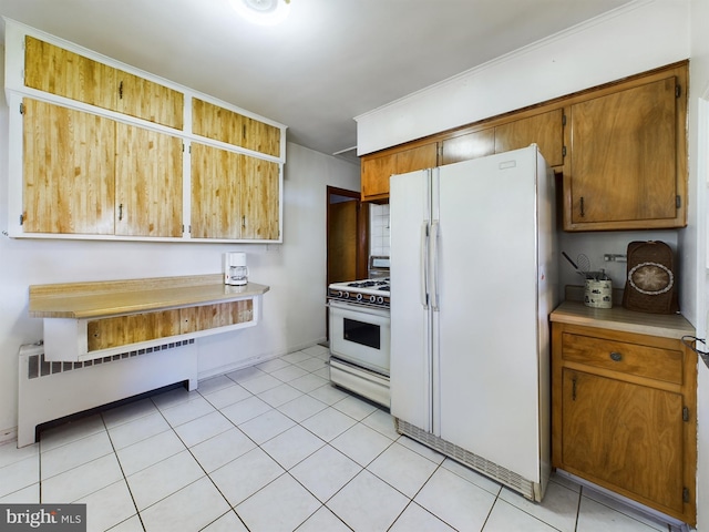 834 Amboy Ave, Edison, NJ 08837 - kitchen with white appliances, radiator heating unit, light countertops, and brown cabinets