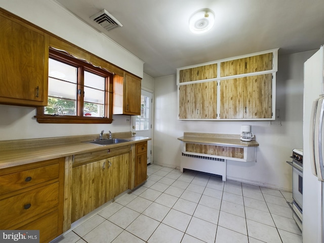 834 Amboy Ave, Edison, NJ 08837 - kitchen with radiator, a sink, stove, light countertops, and brown cabinets