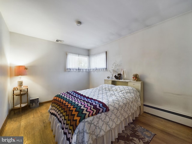 834 Amboy Ave, Edison, NJ 08837 - bedroom featuring a baseboard heating unit, wood finished floors, and baseboards