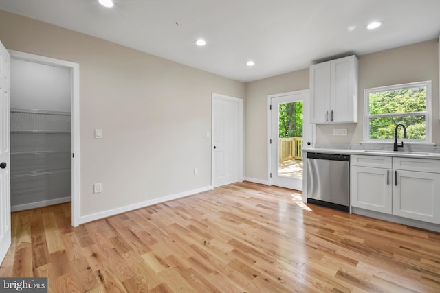 790 Mcdonald Rd, Winchester, VA 22602 - kitchen with stainless steel dishwasher, a sink, light countertops, light wood-style floors, and white cabinets