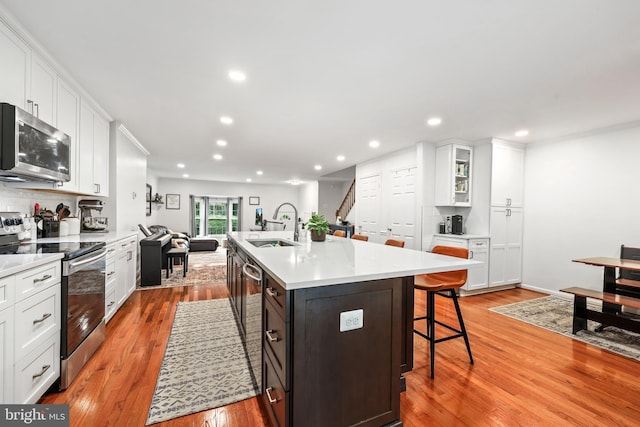 3950 Tallow Tree Pl, Fairfax, VA 22033 - kitchen featuring appliances with stainless steel finishes, a sink, white cabinets, a breakfast bar, and recessed lighting