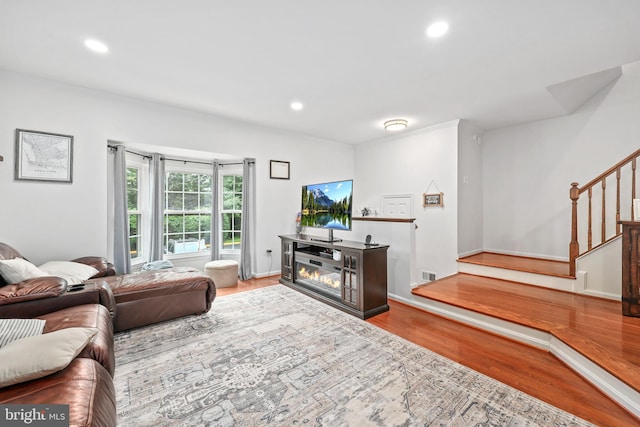 3950 Tallow Tree Pl, Fairfax, VA 22033 - living room with wood finished floors, stairs, recessed lighting, a glass covered fireplace, and baseboards