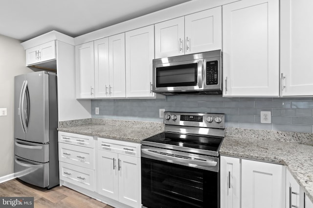 4727 Exeter St, Annandale, VA 22003 - kitchen with stainless steel appliances, white cabinetry, light wood finished floors, and decorative backsplash