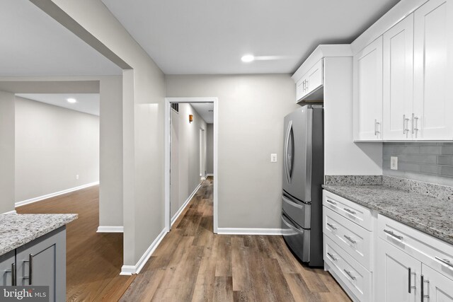 4727 Exeter St, Annandale, VA 22003 - kitchen with freestanding refrigerator, dark wood-style flooring, white cabinets, light stone countertops, and recessed lighting