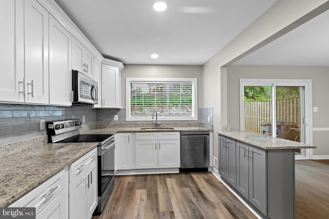 4727 Exeter St, Annandale, VA 22003 - kitchen with stainless steel appliances, a sink, a peninsula, dark wood finished floors, and recessed lighting