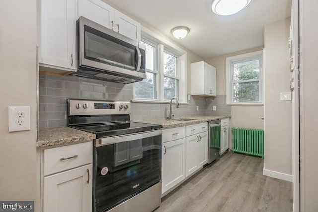 531 Jessamine Ave, Collingswood, NJ 08107 - kitchen featuring stainless steel appliances, radiator, a sink, white cabinets, and light wood-type flooring