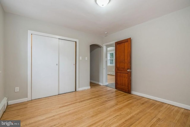 531 Jessamine Ave, Collingswood, NJ 08107 - unfurnished bedroom featuring light wood-style flooring, baseboards, a closet, and arched walkways