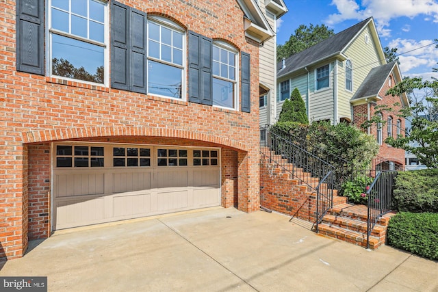 2227 N Albemarle St, Arlington, VA 22207 - view of property exterior with an attached garage, brick siding, and concrete driveway