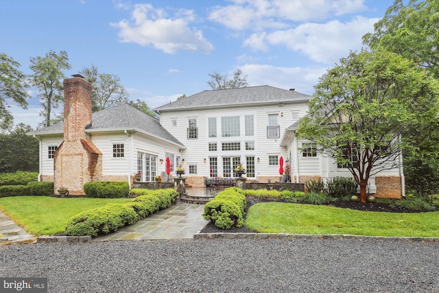 2740 Hunter Mill Rd, Oakton, VA 22124 - rear view of property with a patio, a yard, a shingled roof, and a chimney