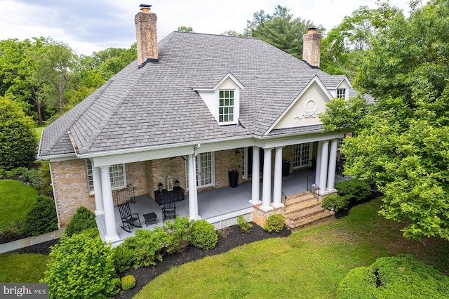 2740 Hunter Mill Rd, Oakton, VA 22124 - back of house featuring a chimney, brick siding, covered porch, a yard, and roof with shingles