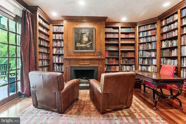 2740 Hunter Mill Rd, Oakton, VA 22124 - sitting room featuring bookshelves, wood finished floors, built in shelves, a fireplace, and recessed lighting
