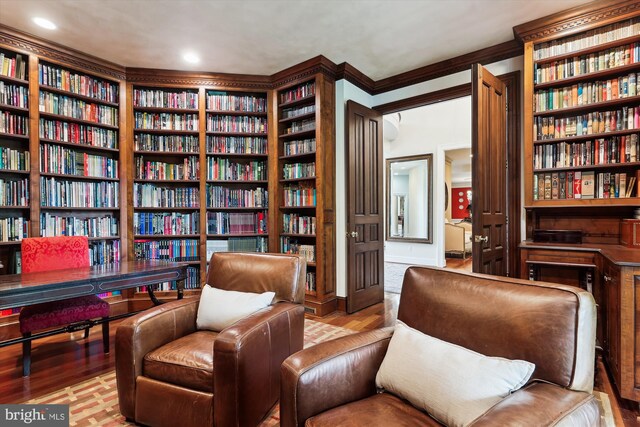 2740 Hunter Mill Rd, Oakton, VA 22124 - sitting room featuring bookshelves, wood finished floors, ornamental molding, built in features, and recessed lighting