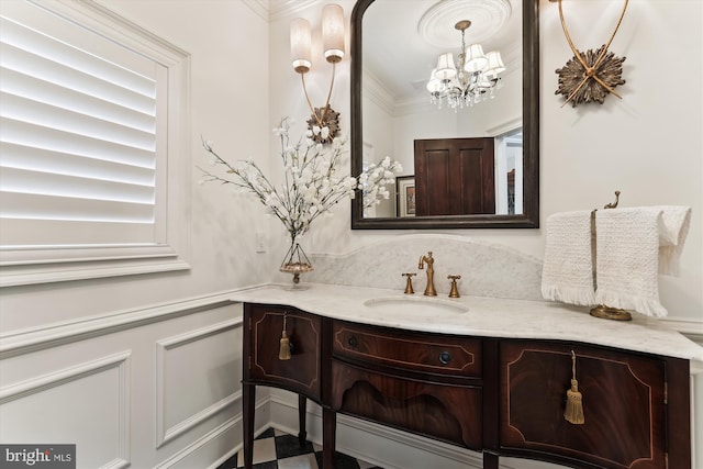 2740 Hunter Mill Rd, Oakton, VA 22124 - bathroom with a chandelier, vanity, crown molding, wainscoting, and a decorative wall