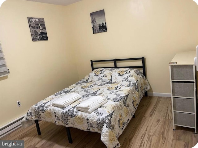 7108 Robinwood Dr, Tobyhanna, PA 18466 - bedroom with a baseboard radiator, wood finished floors, and baseboards