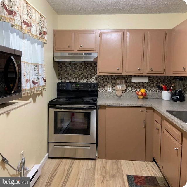 7108 Robinwood Dr, Tobyhanna, PA 18466 - kitchen with stainless steel electric stove, under cabinet range hood, tasteful backsplash, light countertops, and a textured ceiling