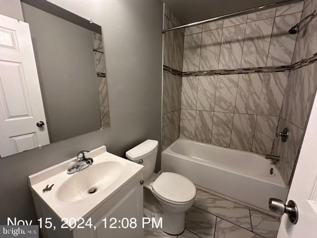 2468 Greenmount Ave, Baltimore, MD 21218 - full bathroom featuring marble look tiles, vanity, toilet, and shower / washtub combination