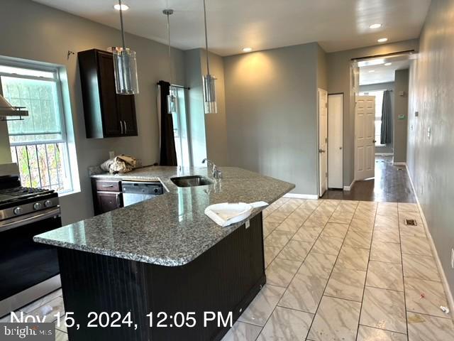 2468 Greenmount Ave, Baltimore, MD 21218 - kitchen with gas range, a sink, dishwasher, stone countertops, and baseboards