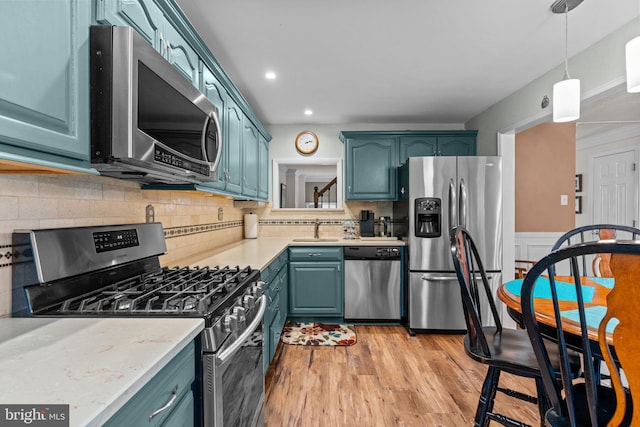 3778 Westhampton Dr, Philadelphia, PA 19154 - kitchen with stainless steel appliances, a sink, light countertops, light wood-style floors, and pendant lighting