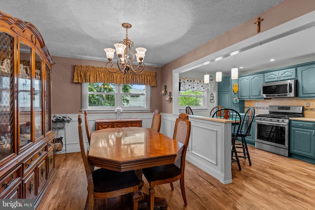 3778 Westhampton Dr, Philadelphia, PA 19154 - dining room with a chandelier, light wood-type flooring, a textured ceiling, and wainscoting