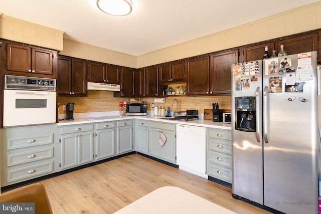 5143 Venice Ave, Hammonton, NJ 08037 - kitchen with white appliances, under cabinet range hood, a sink, light countertops, and light wood-style floors