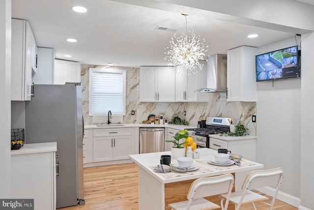 5300 Merceron Ave, Baltimore, MD 21207 - kitchen with wall chimney exhaust hood, stainless steel appliances, a sink, white cabinets, and recessed lighting