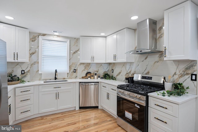 5300 Merceron Ave, Baltimore, MD 21207 - kitchen featuring appliances with stainless steel finishes, wall chimney exhaust hood, a sink, white cabinets, and recessed lighting