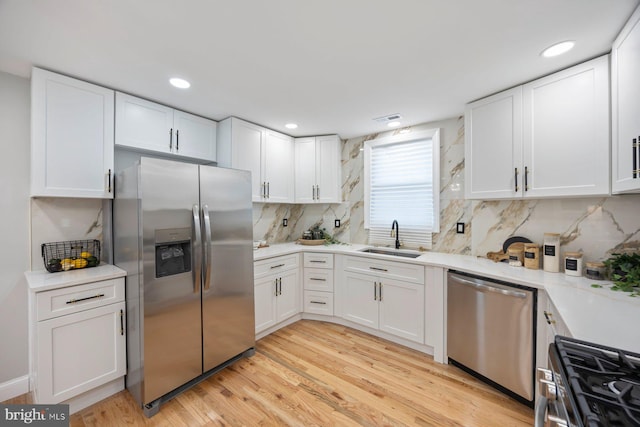 5300 Merceron Ave, Baltimore, MD 21207 - kitchen with stainless steel appliances, a sink, white cabinetry, backsplash, and light countertops