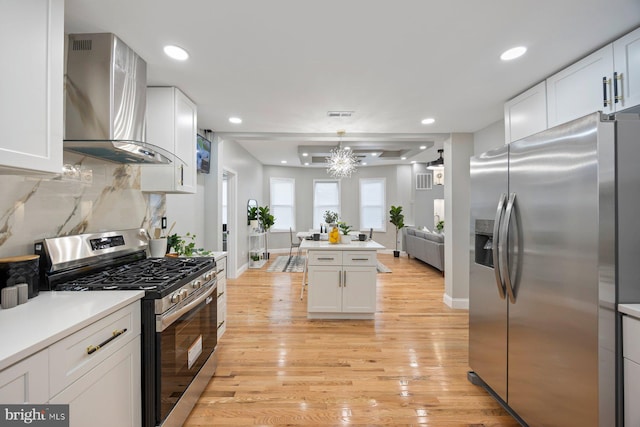 5300 Merceron Ave, Baltimore, MD 21207 - kitchen with stainless steel appliances, wall chimney range hood, light wood-style flooring, white cabinets, and open floor plan