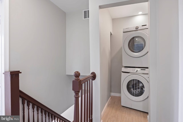 5300 Merceron Ave, Baltimore, MD 21207 - laundry room with stacked washing machine and dryer, light wood finished floors, and baseboards