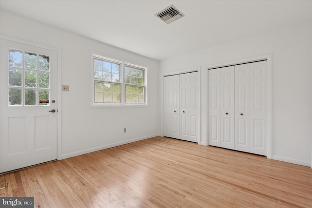 425 Wister Rd, Wynnewood, PA 19096 - unfurnished bedroom with multiple windows, wood finished floors, multiple closets, and baseboards