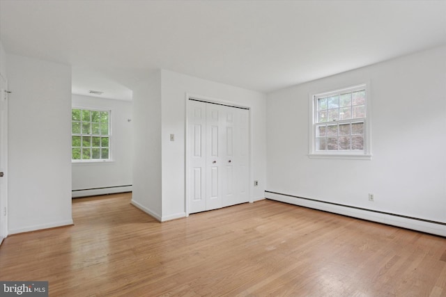 425 Wister Rd, Wynnewood, PA 19096 - unfurnished bedroom featuring a baseboard radiator, light wood-style flooring, and a closet