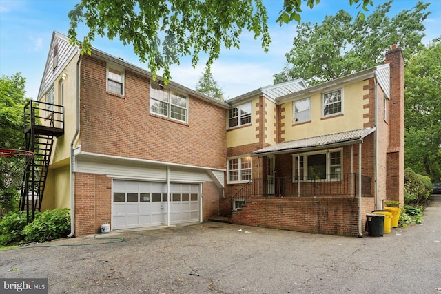 425 Wister Rd, Wynnewood, PA 19096 - view of front of property with stairs, brick siding, driveway, a garage, and a chimney