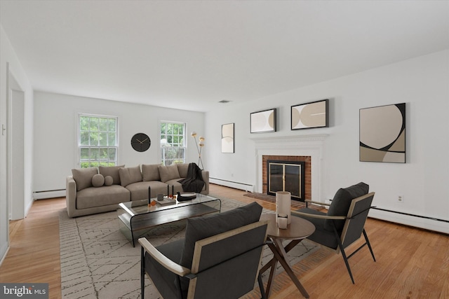 425 Wister Rd, Wynnewood, PA 19096 - living room featuring baseboard heating, a baseboard radiator, a fireplace, and light wood-style flooring