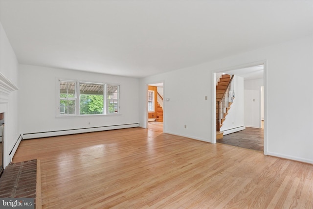 425 Wister Rd, Wynnewood, PA 19096 - unfurnished living room with stairway, a baseboard heating unit, baseboard heating, wood finished floors, and a brick fireplace