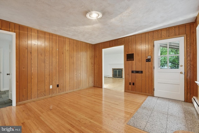 425 Wister Rd, Wynnewood, PA 19096 - foyer with wood finished floors, wood walls, a baseboard heating unit, baseboards, and a textured ceiling