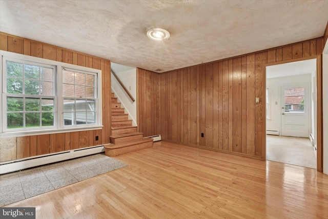 425 Wister Rd, Wynnewood, PA 19096 - unfurnished room featuring wooden walls, stairs, baseboard heating, and wood finished floors