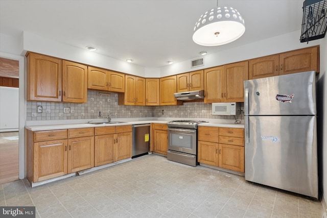 425 Wister Rd, Wynnewood, PA 19096 - kitchen with appliances with stainless steel finishes, a sink, under cabinet range hood, and light countertops