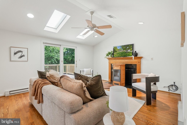 26140 Mullinix Mill Rd, Mount Airy, MD 21771 - living room featuring a baseboard heating unit, a skylight, a fireplace with flush hearth, and wood finished floors