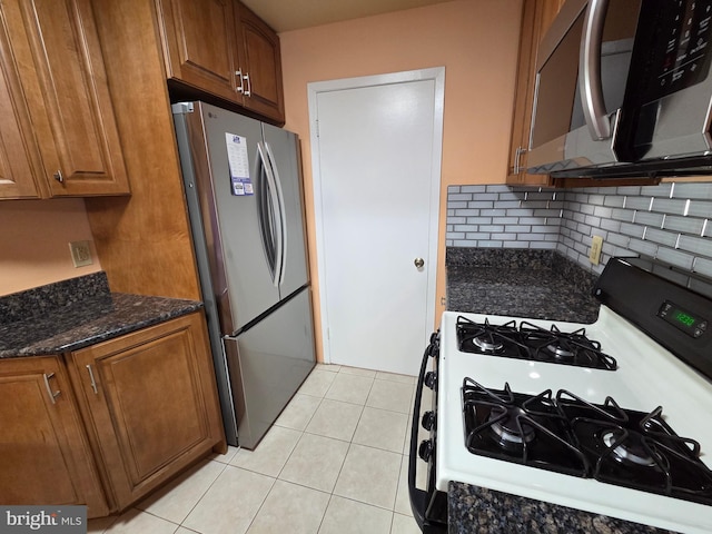 2704 Adams Ct, North Wales, PA 19454 - kitchen featuring appliances with stainless steel finishes, tasteful backsplash, dark stone counters, brown cabinets, and light tile patterned floors